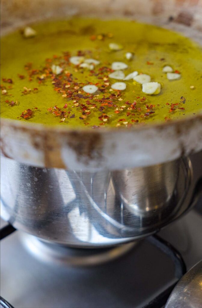 placing pan on pot of steaming water